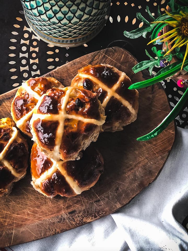 Fruity hot cross buns with shiny apricot glaze.