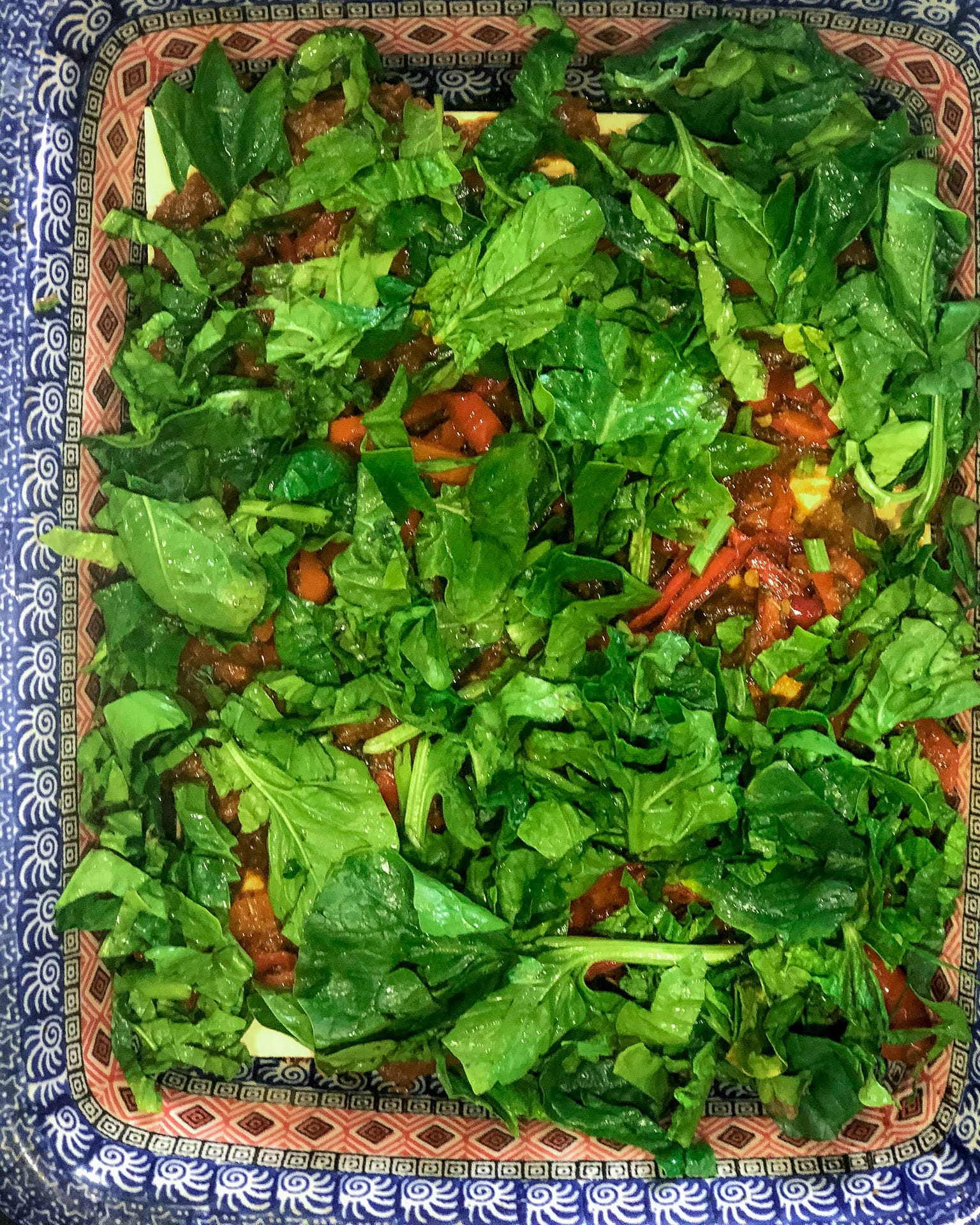 Lasagne alle Verdure topped with greens in a classic Italian dish.