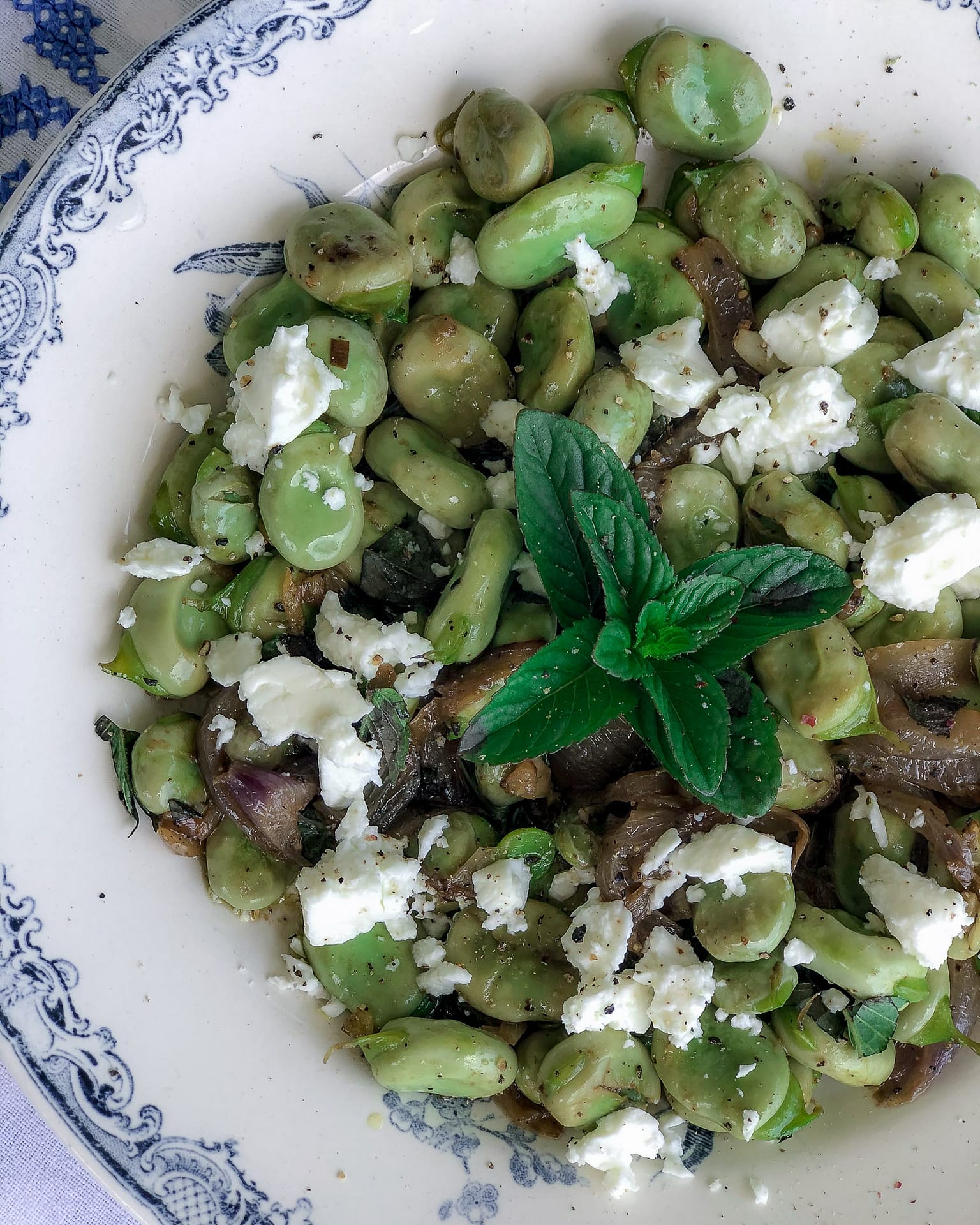 Blue and white bowl with broad beads, mint and feta.