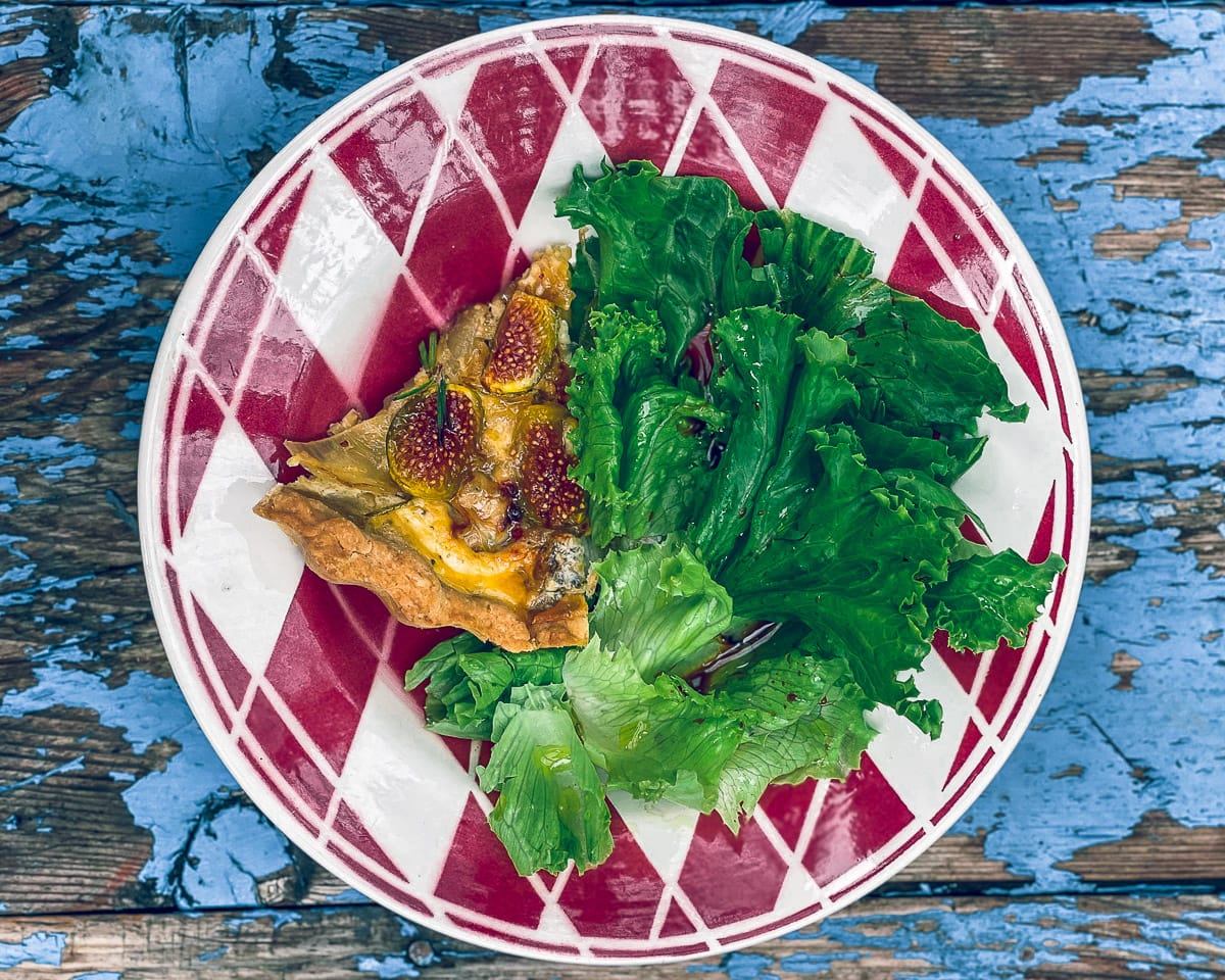 Fig and Gorgonzola Tart with some salad on a beautiful patterned plate
