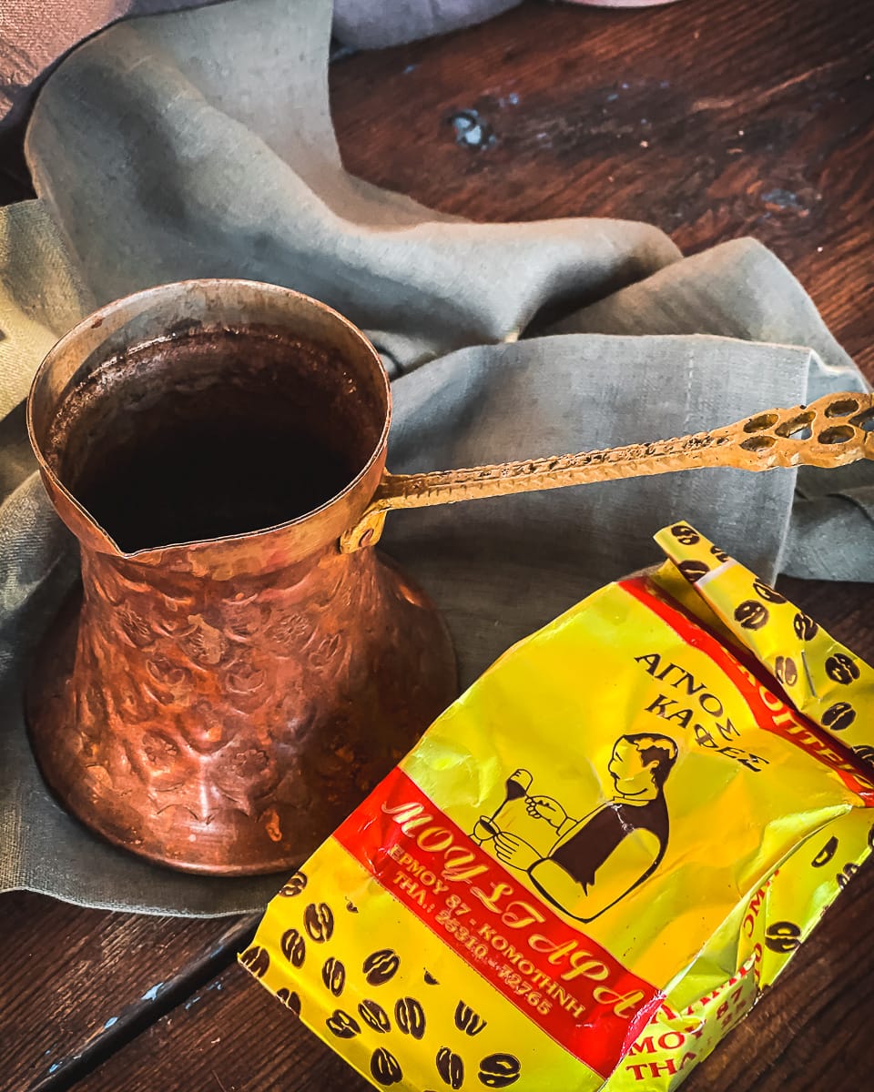 A traditional Greek briki with a packet of ground Greek coffee