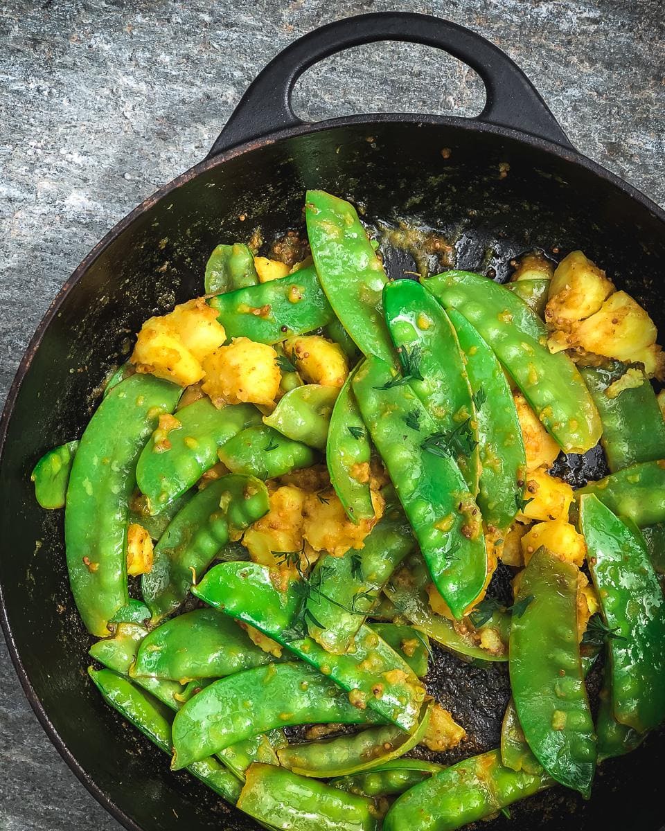Stir fried mangetout and potatoes garnished with fresh coriander
