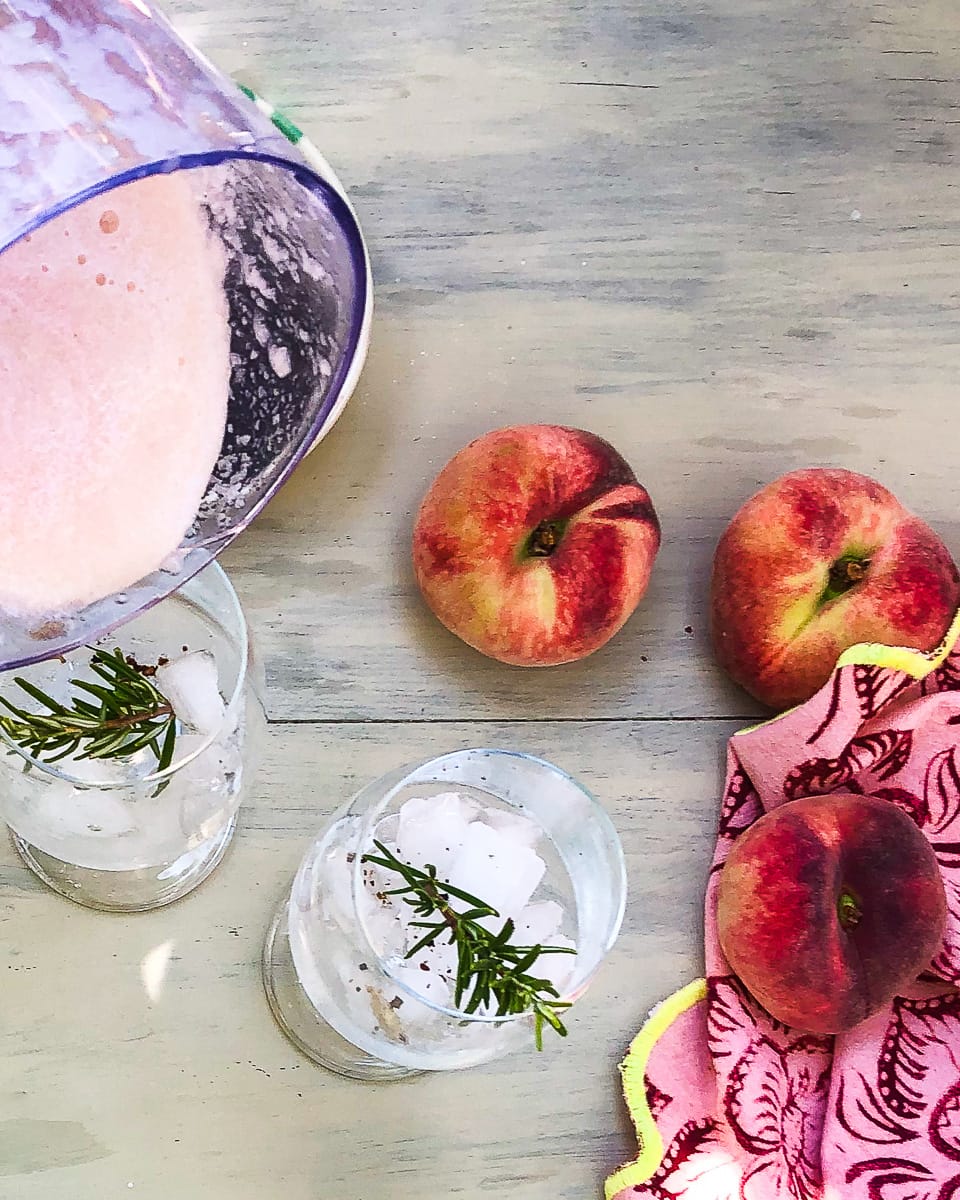 White peach puree added to chilled glassed for Rosemary Peach Bellini