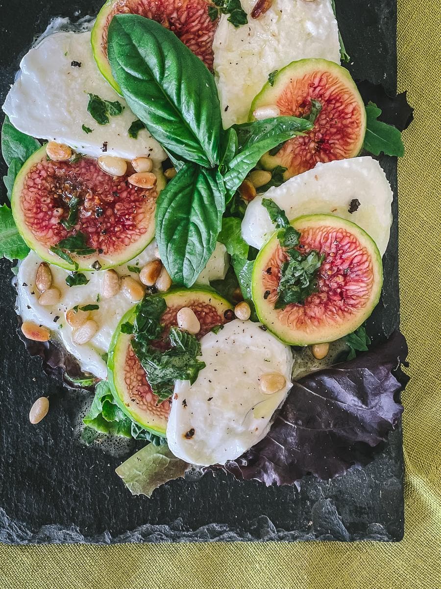 Fig Caprese served on a dark slate platter.