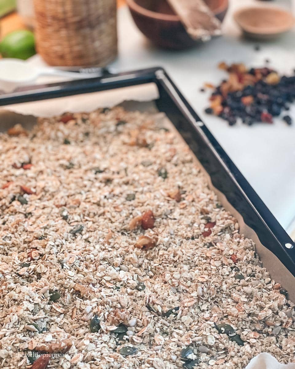A batch of homemade granola in a baking tray ready for the oven.