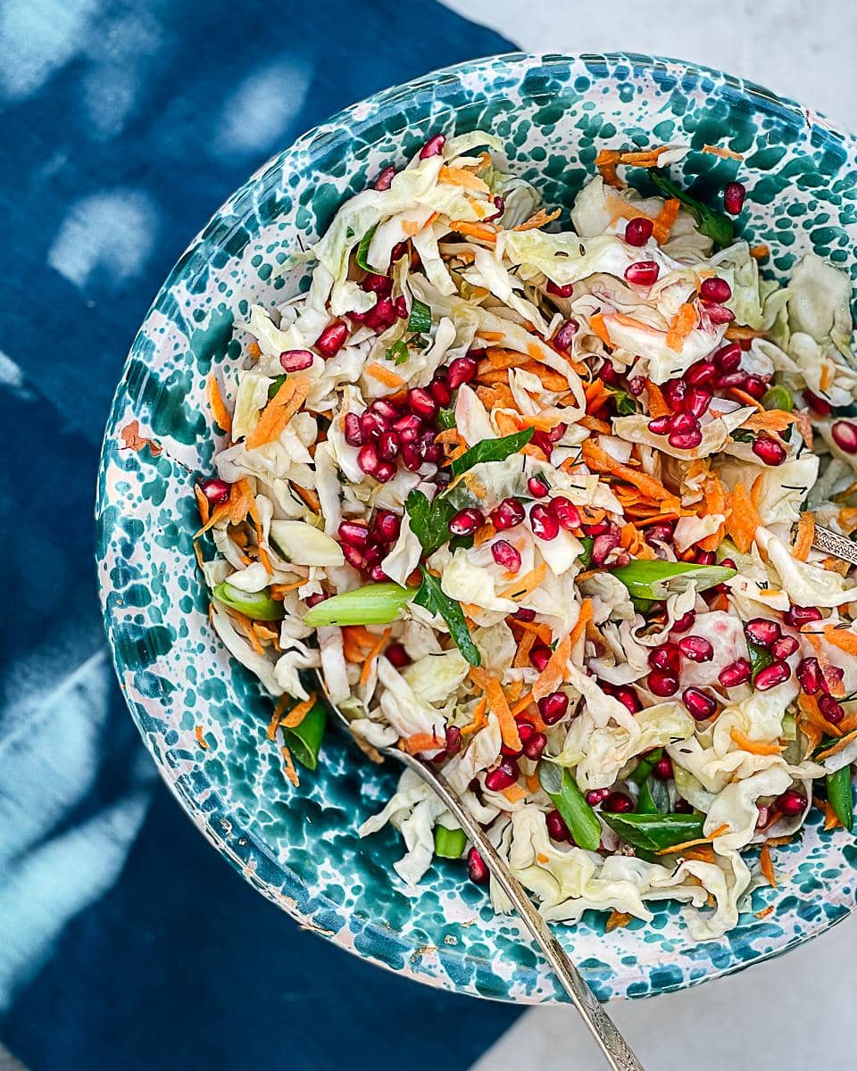 Decorative blue salad bowl filled with colourful cabbage salad.