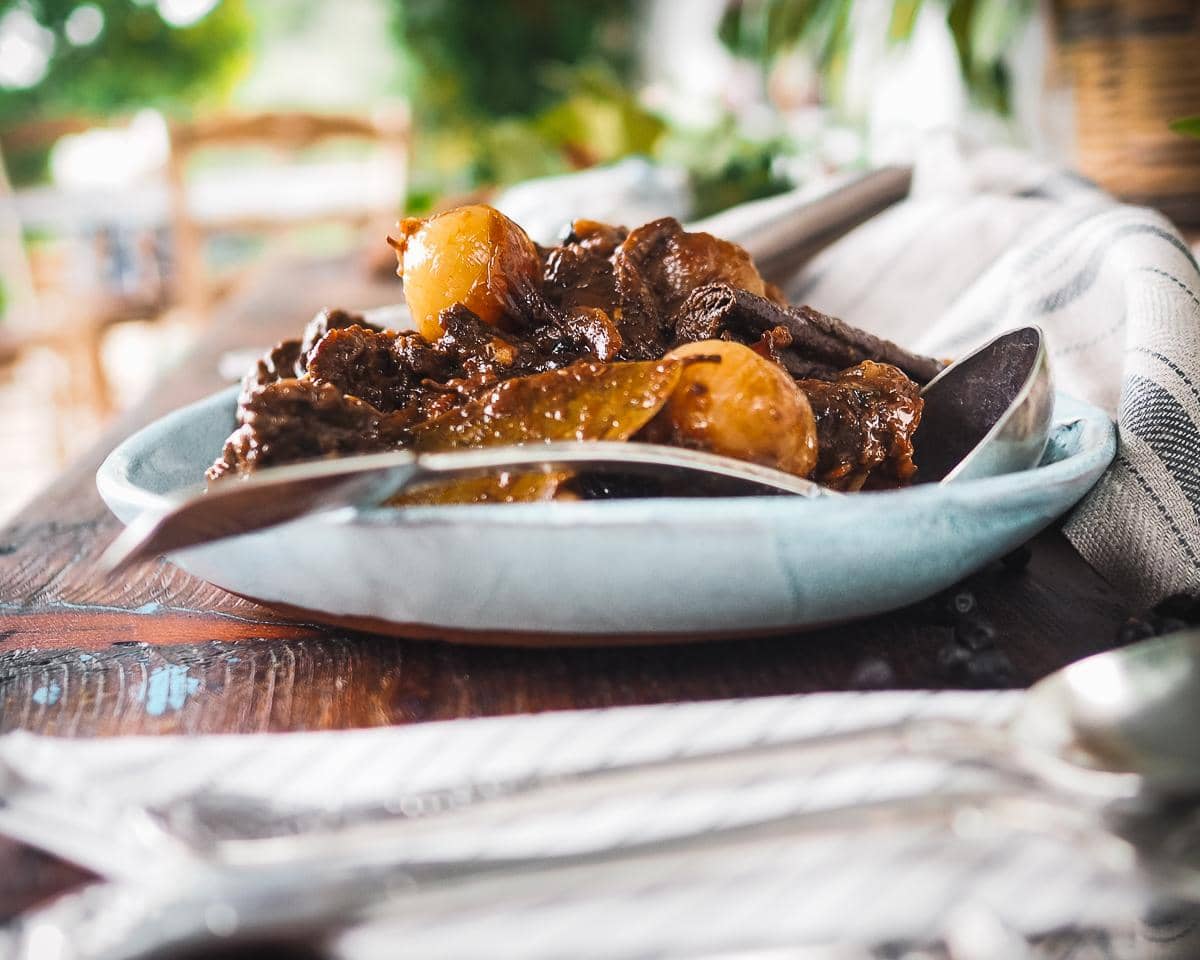 Beef stifado served in a pale blue bowl