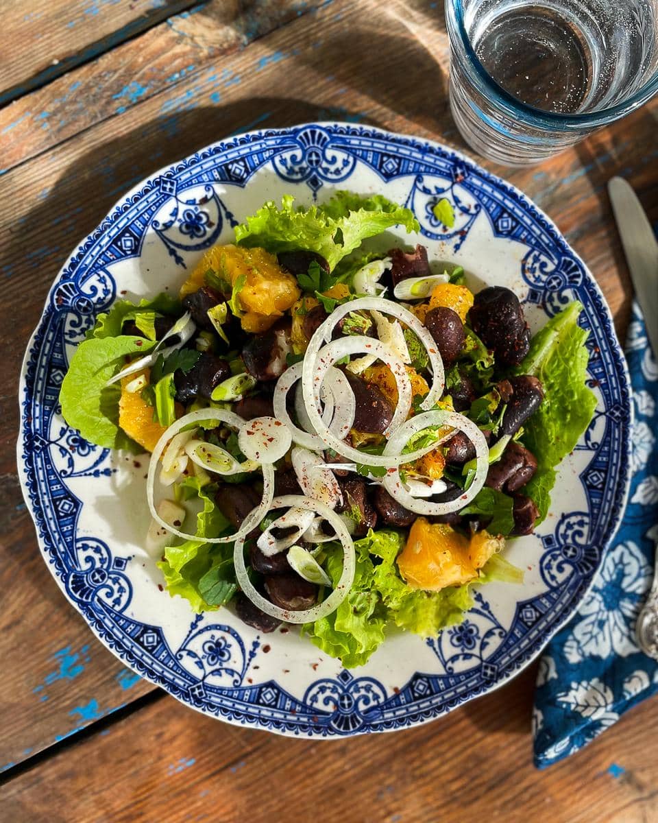 Gigantes bean and orange salad served on a pretty blue and white plate