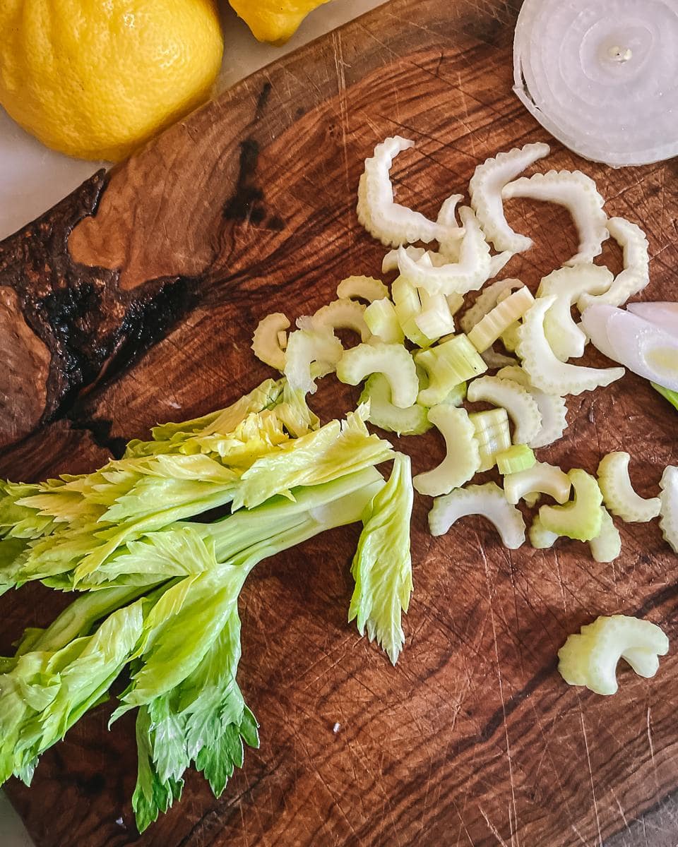 Olive chopping board with finely chopped celery stalks