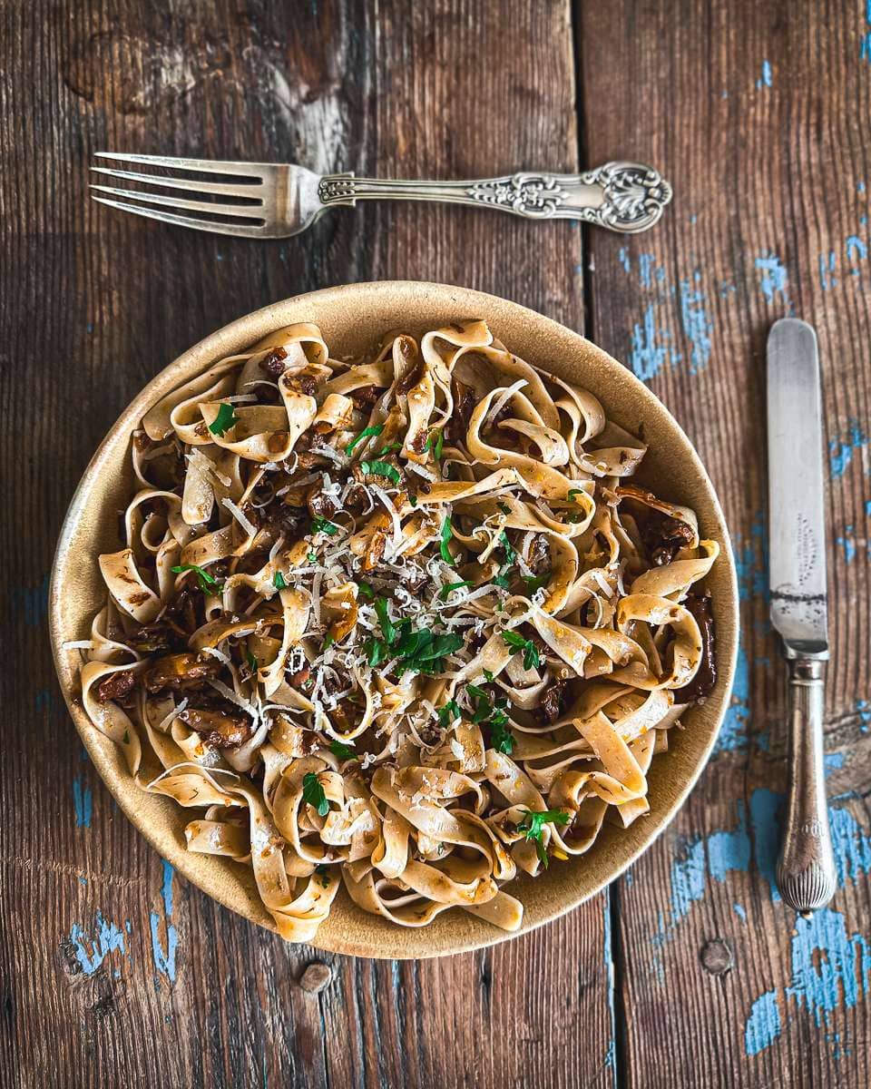 Wild mushroom ragu pasta served in a handmade pottery bowl
