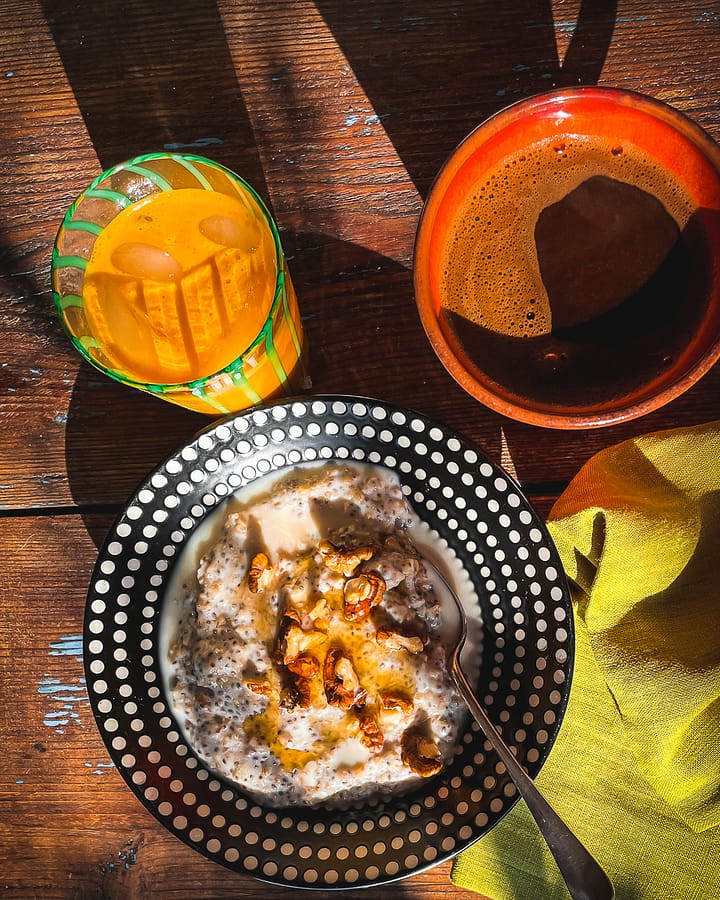 Sunny breakfast scene with porridge, greek coffee and freshly squeezed orange juice.