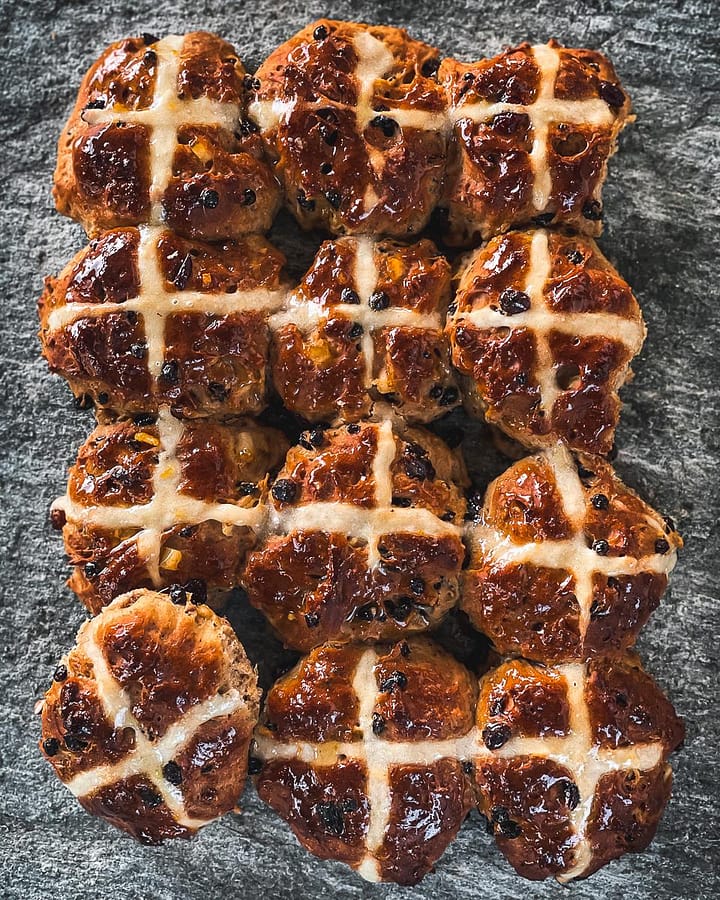 Fresh from the oven, fruity hot cross buns made with 50/50 wholemeal and white flour