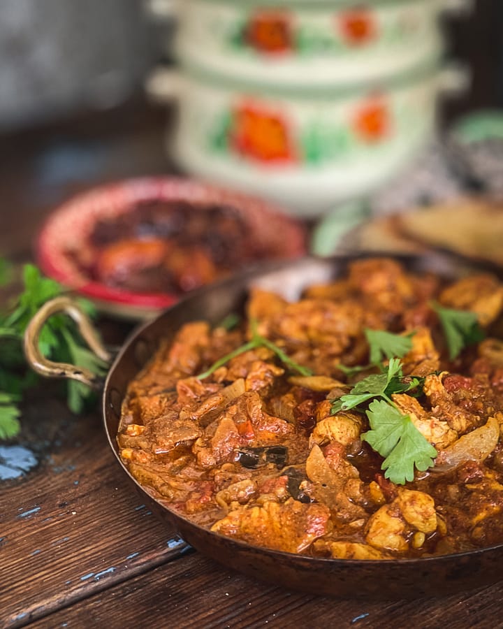 Chicken Chettinad served in a kadai/kadhai with chutney and naan bread