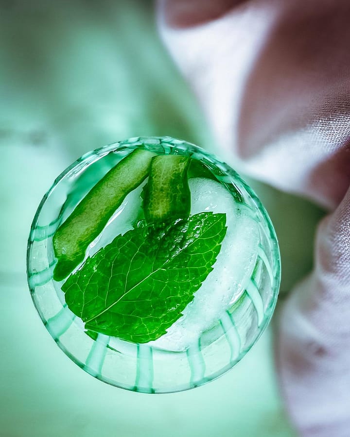 Icy glass of cucumber water garnished with min.