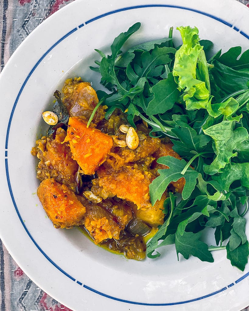 Butternut Ginger Curry with rocket salad in a ceramic bowl