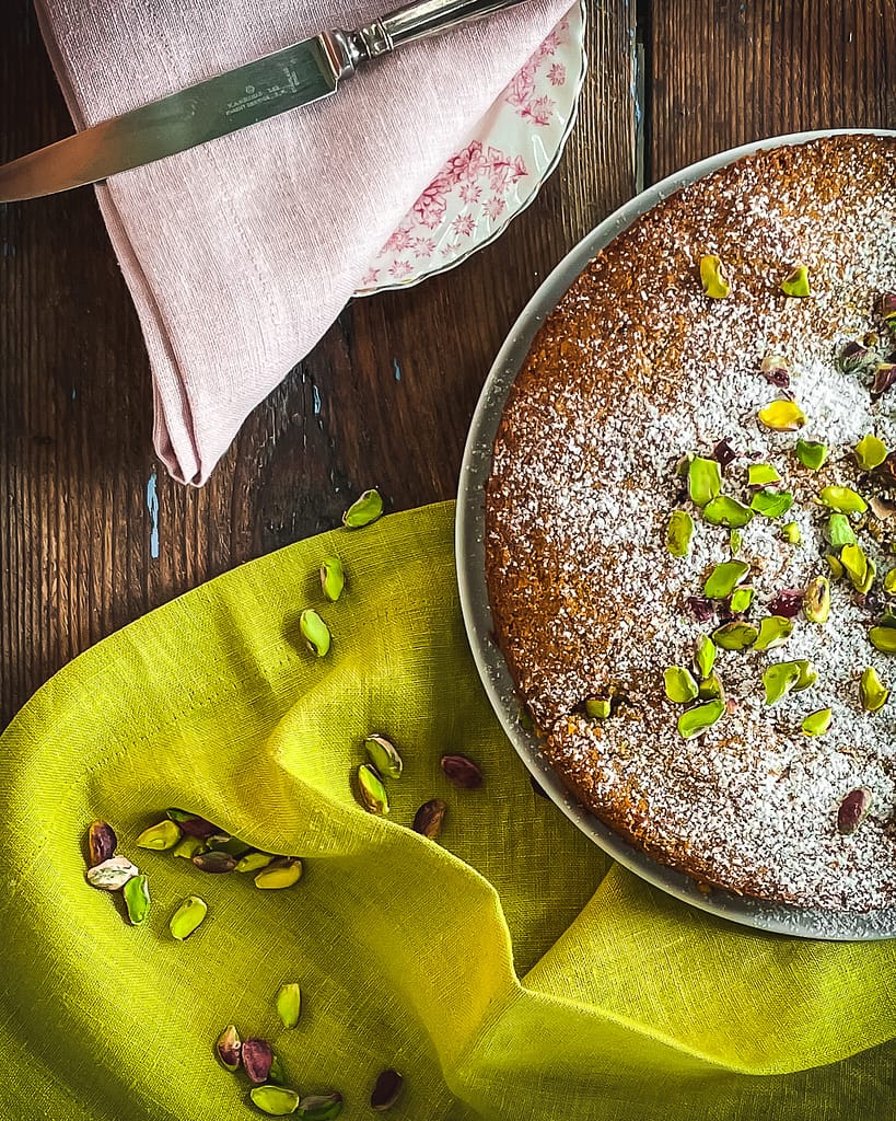 Sfouf cake decorated with bright green pistachos and a dusting of sugar powder.