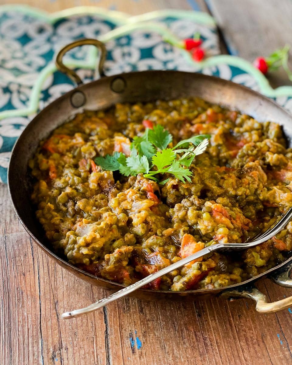 Mung bean curry, garnished with fresh coriander served in a traditional Indian copper handi.